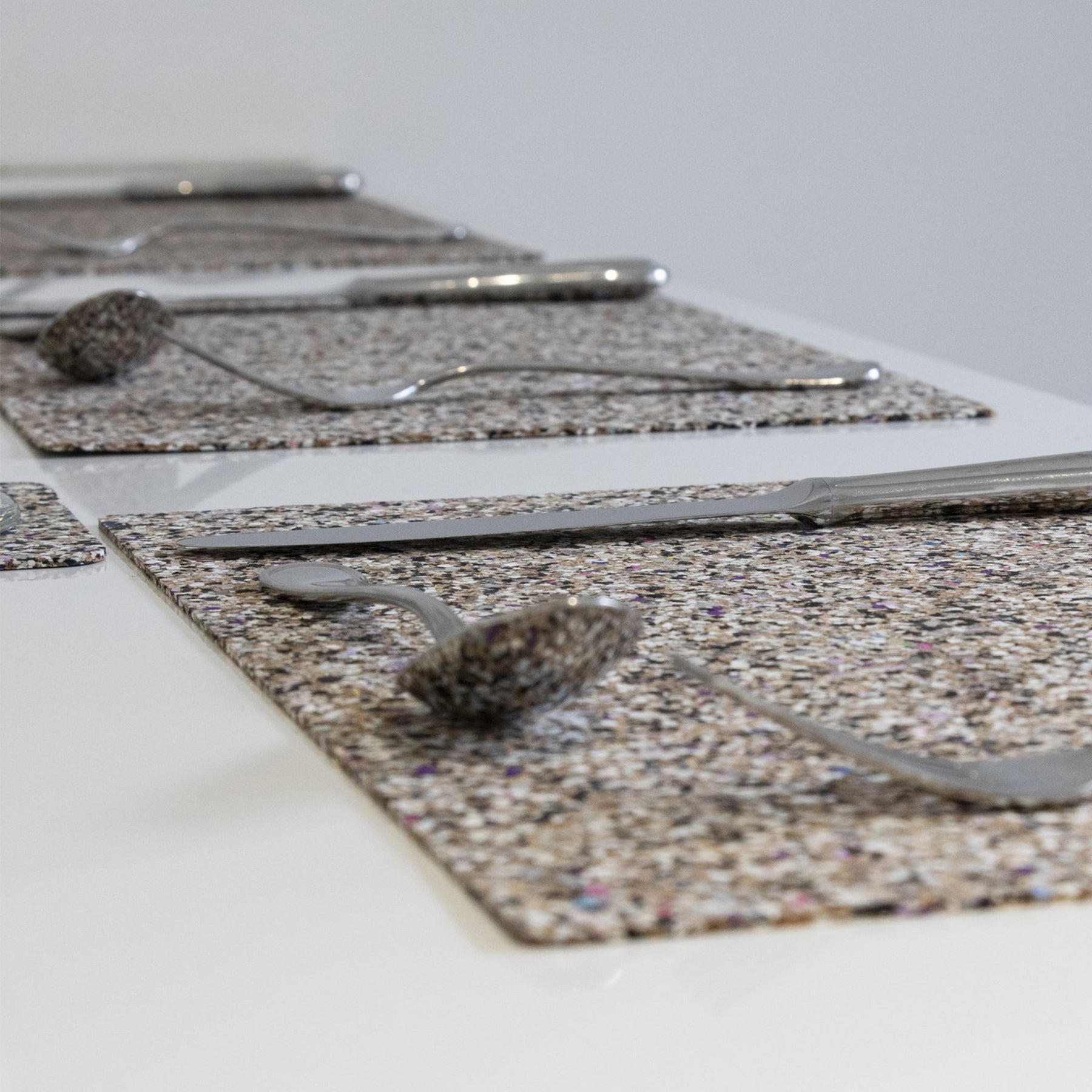 Close up of the placemats on a table with cutlery