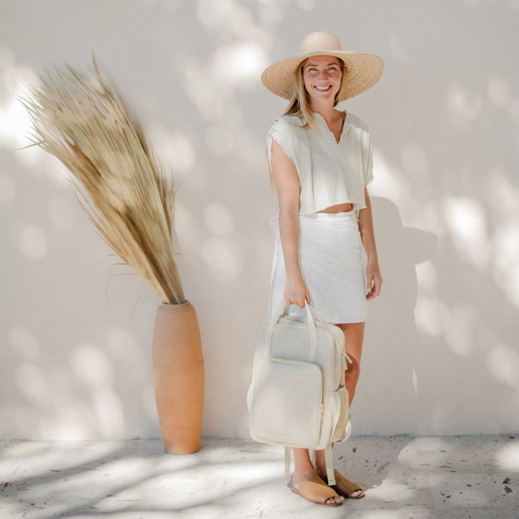 Woman holding her backpack by the top carry handle