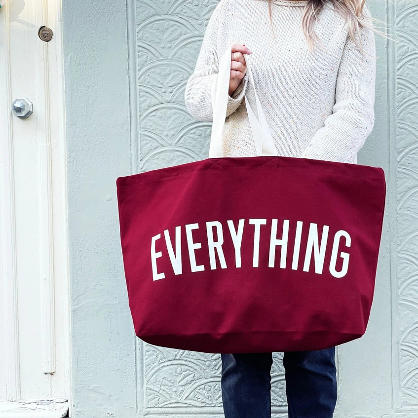 Woman holding the extra large tote bag in front of her.