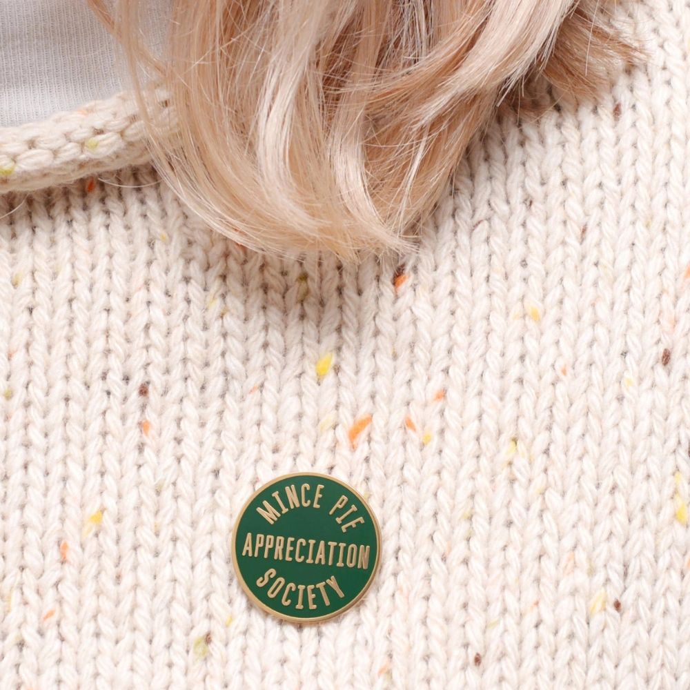 The pin badge shown on a cream jumper