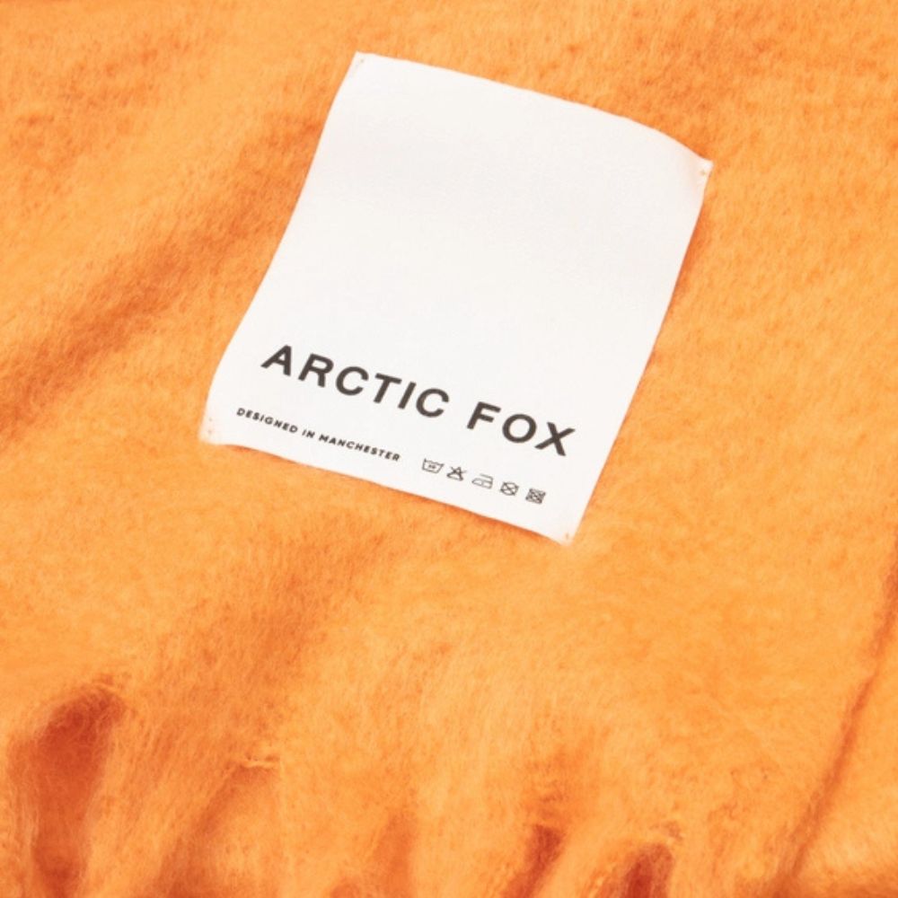 Close up of the Arctic Fox & Co label which says 'designed in Manchester' along with the wash instructions