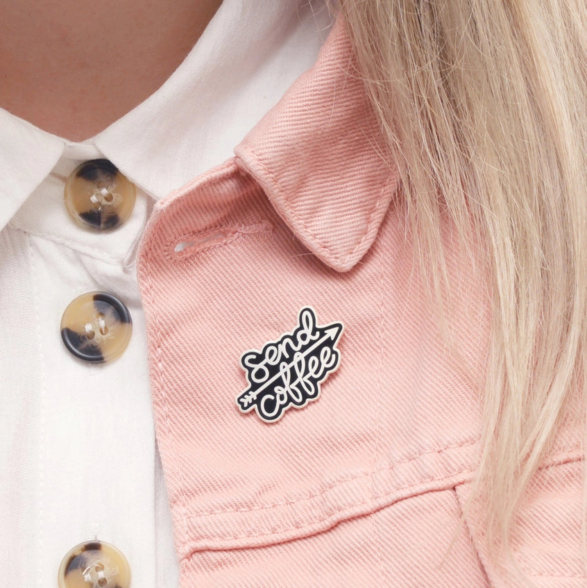 Send coffee badge pinned to a woman's pink denim jacket lapel.