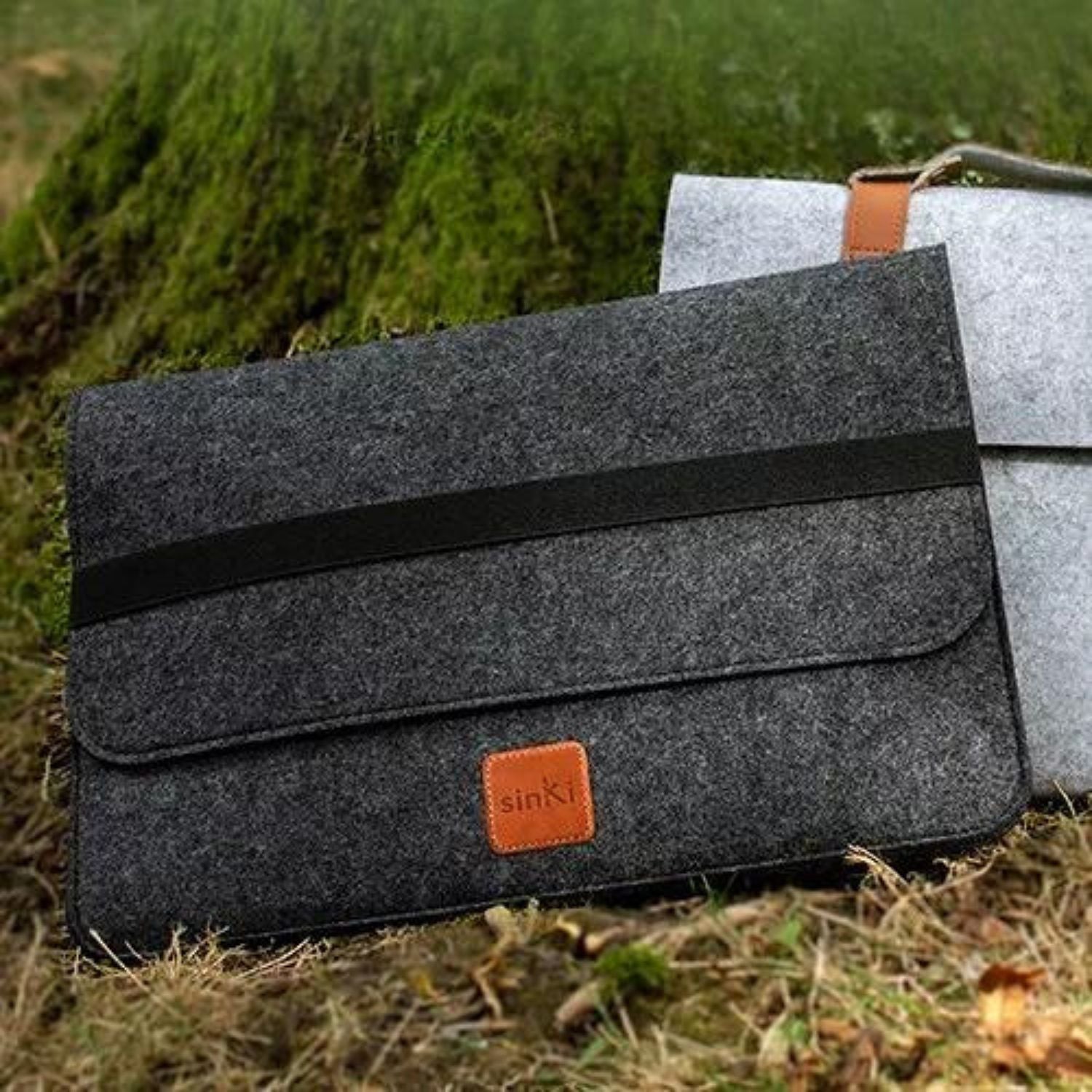 Dark grey laptop sleeve shown on grass