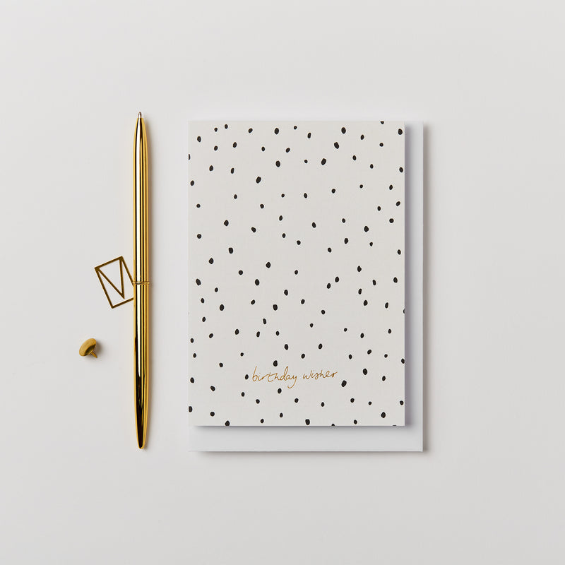 White birthday card with black dots and gold foil text birthday wishes