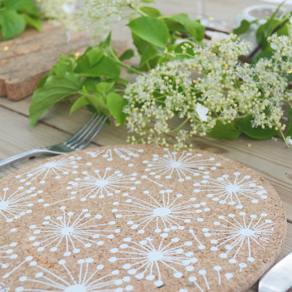 Cork placemats with dandelion design shown on a wooden table