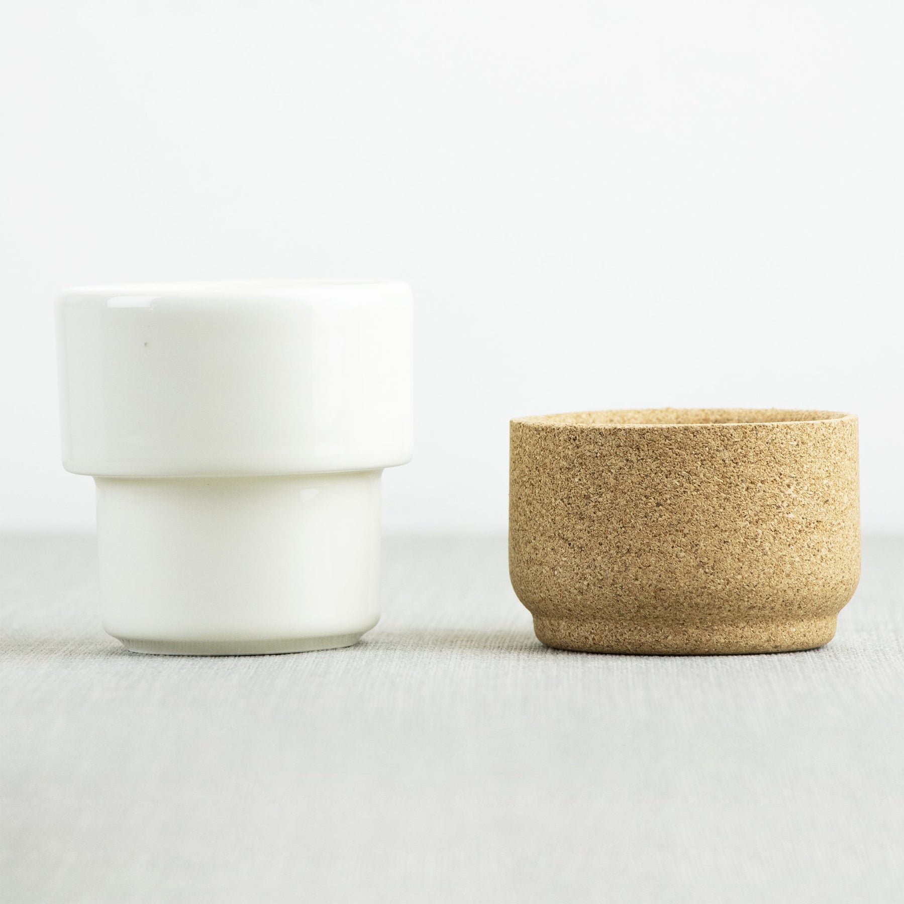 The separate parts of the handleless mug, ceramic and cork