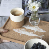 The handleless mug shown on a cork tray